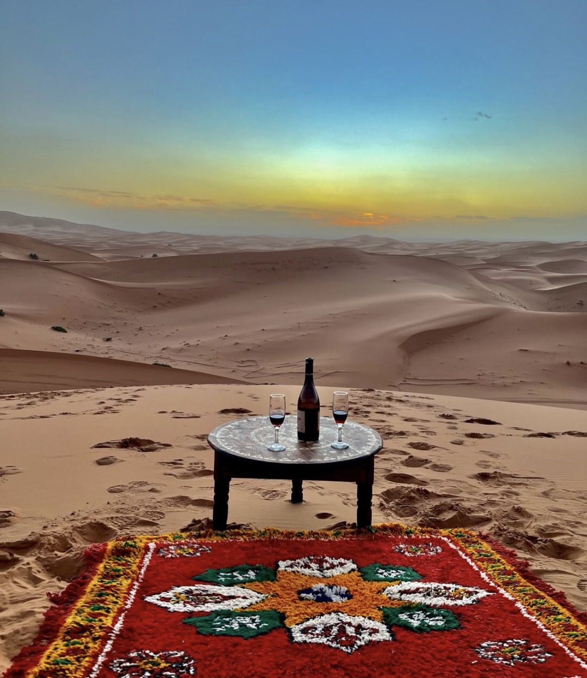 First aid kit and water bottles laid out in the shade of a desert camp tent near Erg Chebbi, Morocco